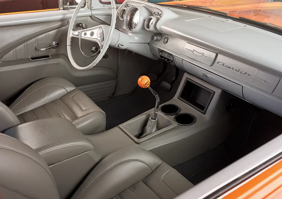 1957 Chevrolet Bel Air custom interior featuring modern bucket seats, a sleek dashboard, and a Hurst shifter