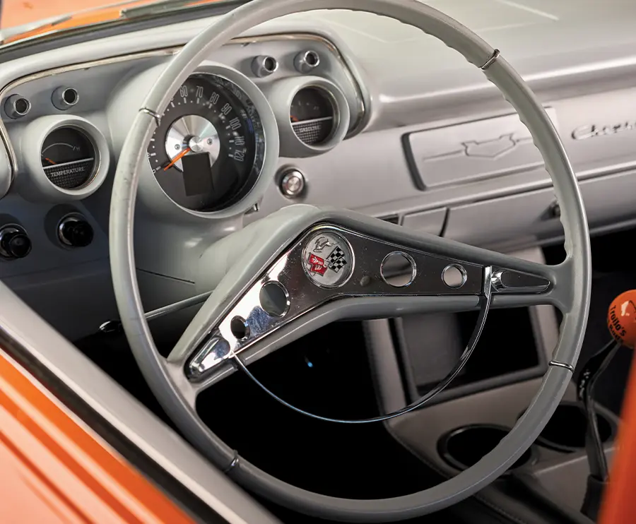 1957 Chevrolet Bel Air featuring a classic chrome-rimmed steering wheel with Corvette emblem and a retro-modern dash