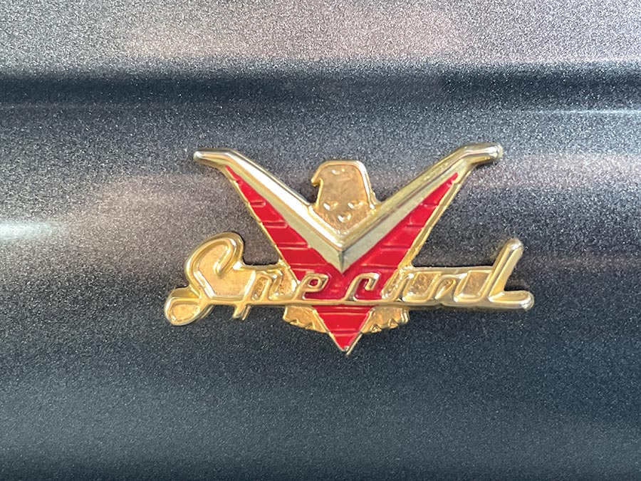 1957 Ford Custom emblem displaying Special in gold script with a red V and eagle accent