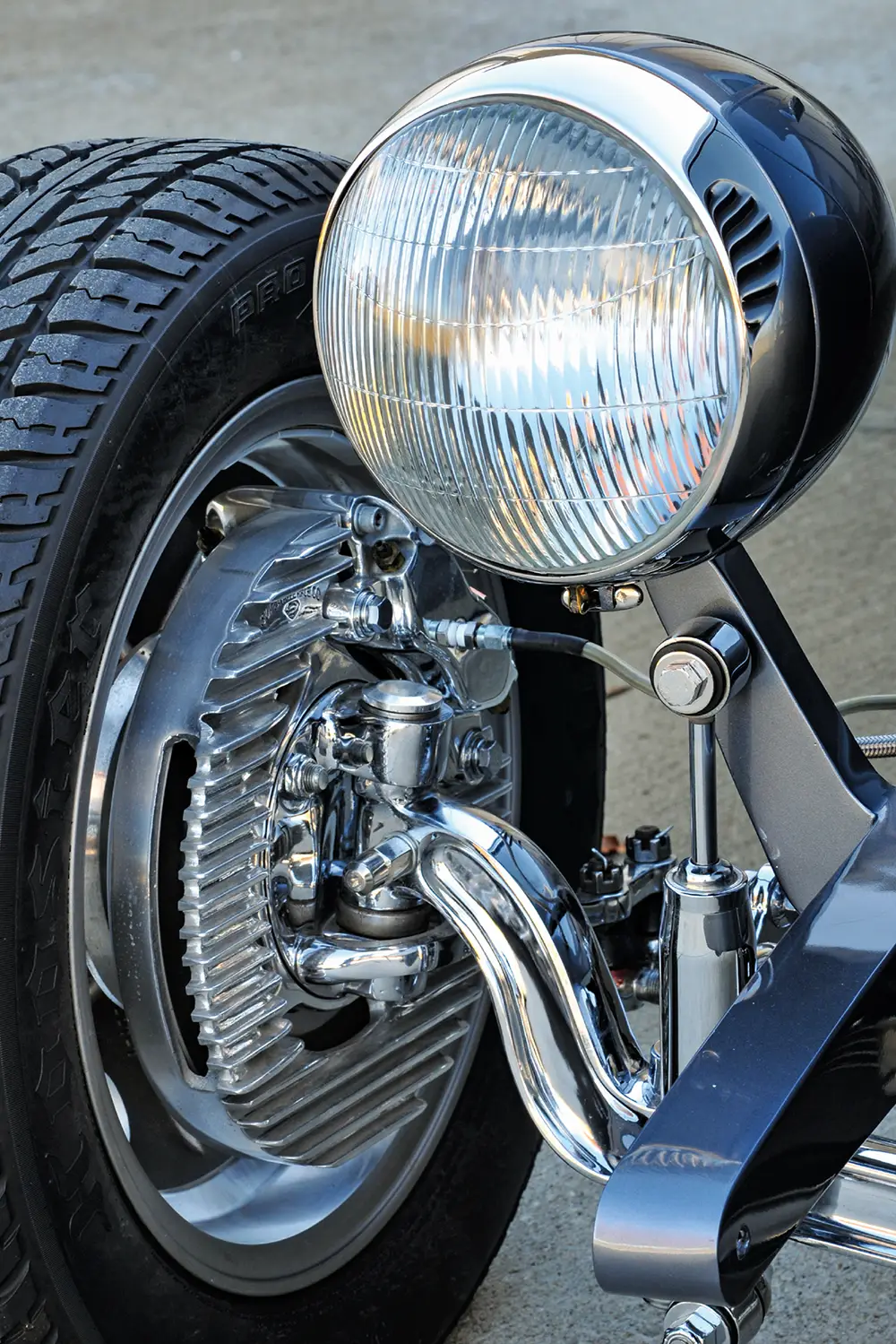 Close-up of a vintage motorcycle's front wheel and headlight.