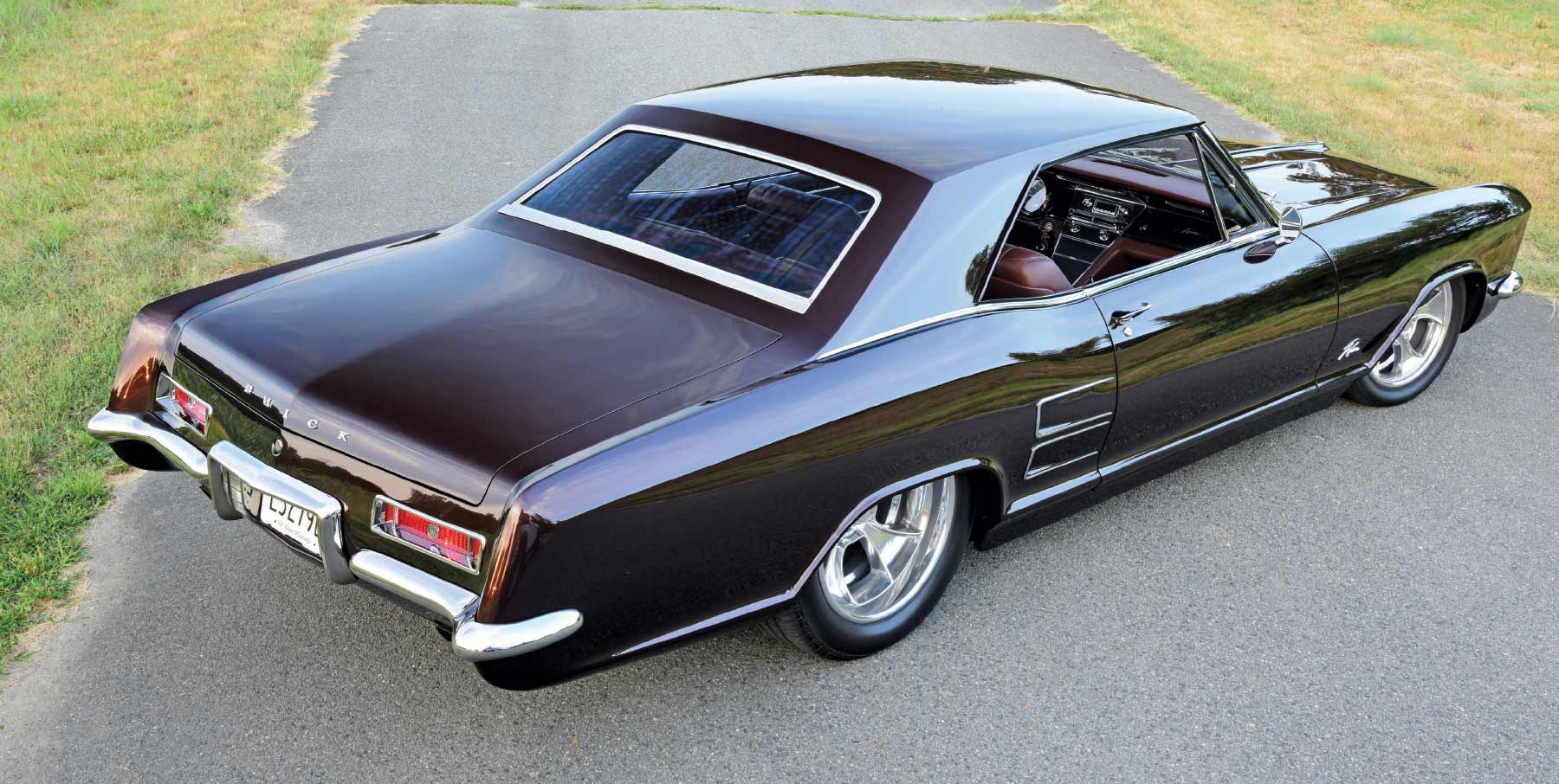 1963 Buick Riviera rolling shot with black paint, custom interior, and lowered stance