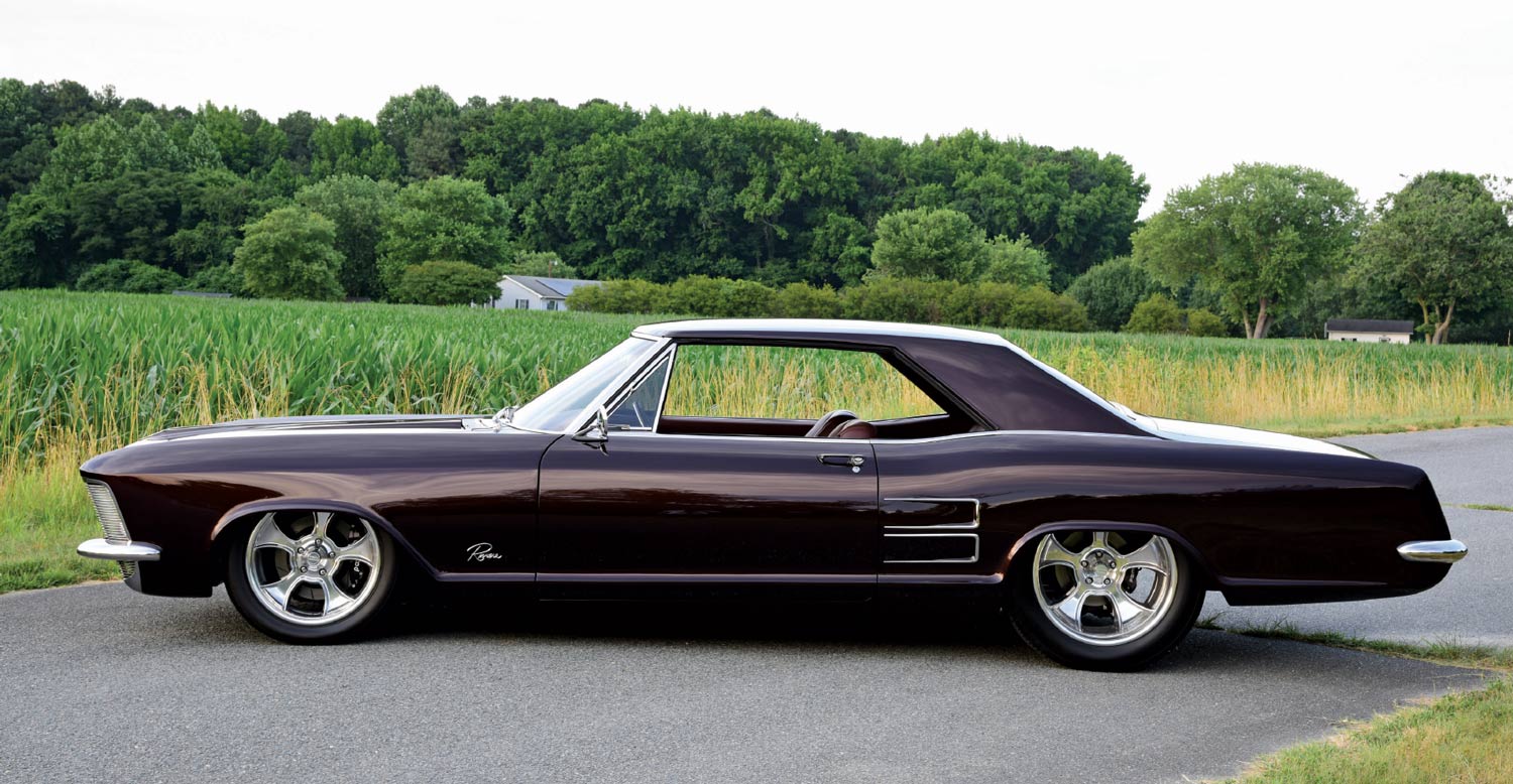 1963 Buick Riviera custom lowrider on polished five-spoke wheels with deep metallic paint and chrome trim
