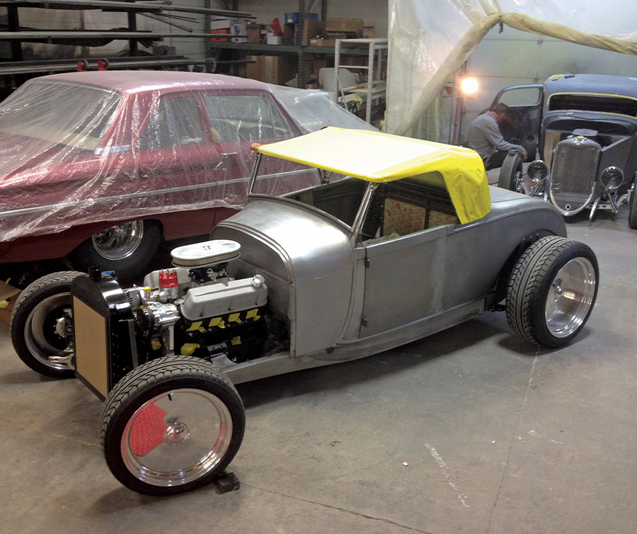 Yellow vinyl mock-up on highboy roadster, taped down for shaping custom top profile