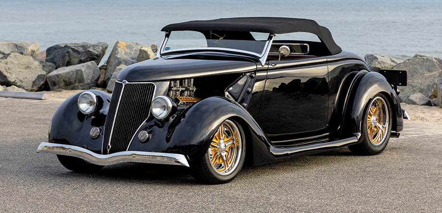1936 Ford Cabriolet with black soft top, gold billet wheels, and lakeside backdrop