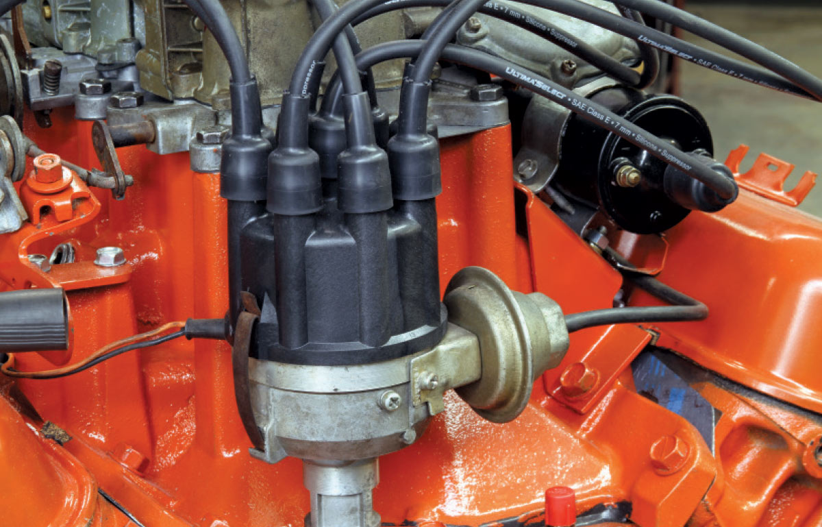 Mopar 340 distributor and coil installed with vacuum advance visible on driver's side