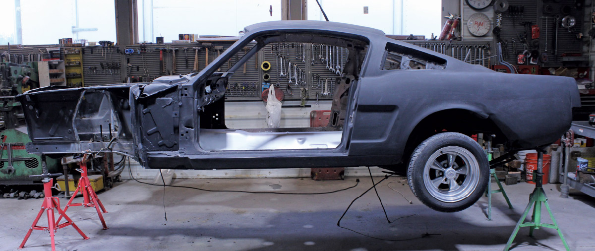 1965 Mustang fastback body on jack stands during restoration