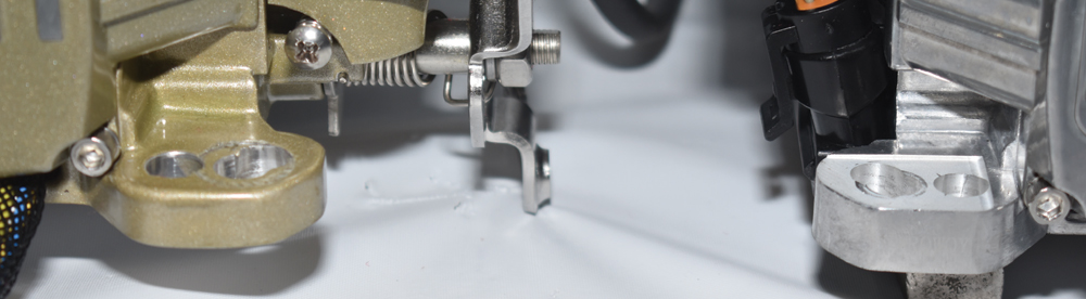 Mounting base comparison of gold and aluminum FiTech throttle bodies with bolt hole spacing