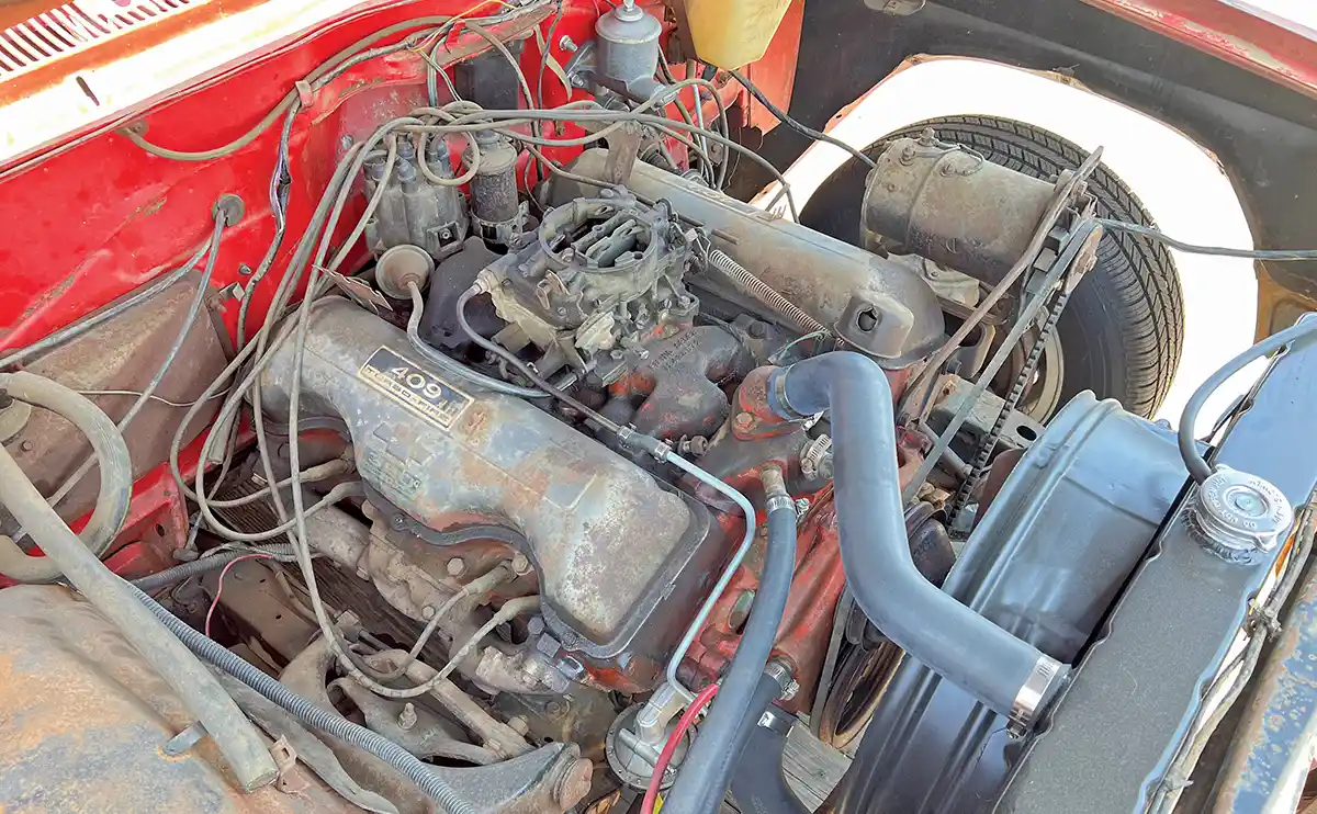 1962 Chevy Impala 409 engine bay with factory dual quad intake and original valve covers