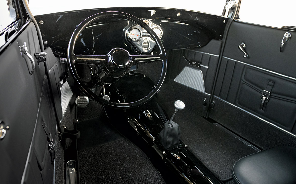 1929 Ford Tudor interior with gloss black dash, billet pedals, and Lokar shifter