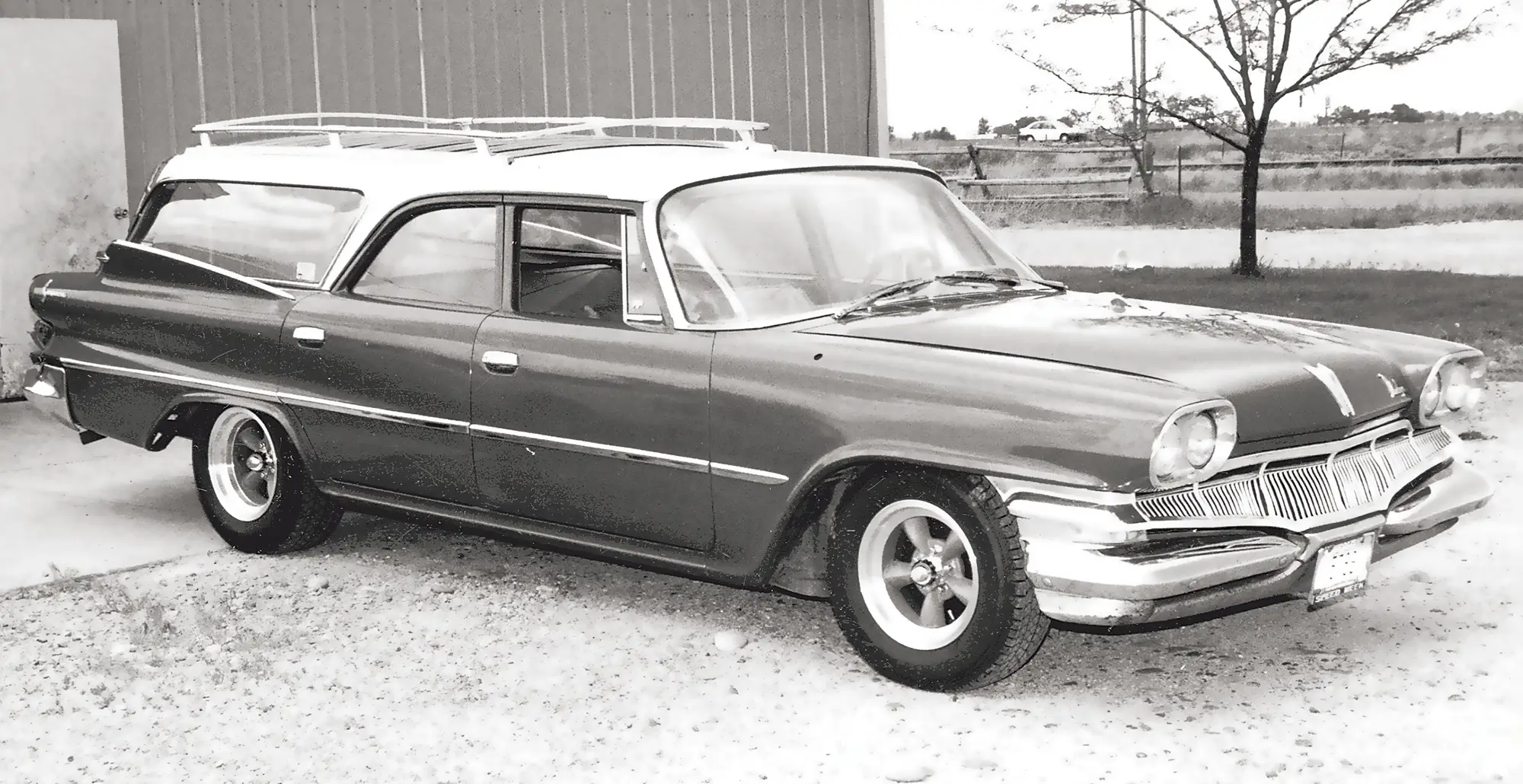 1958 dodge suburban wagon custom wheels roof rack classic two-tone parked beside garage