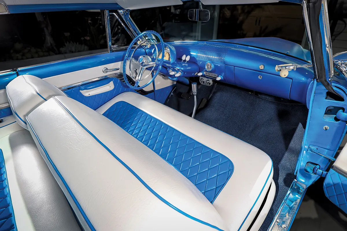 Custom classic car interior with white leather seats, blue diamond-quilted inserts, and a blue dashboard and steering wheel