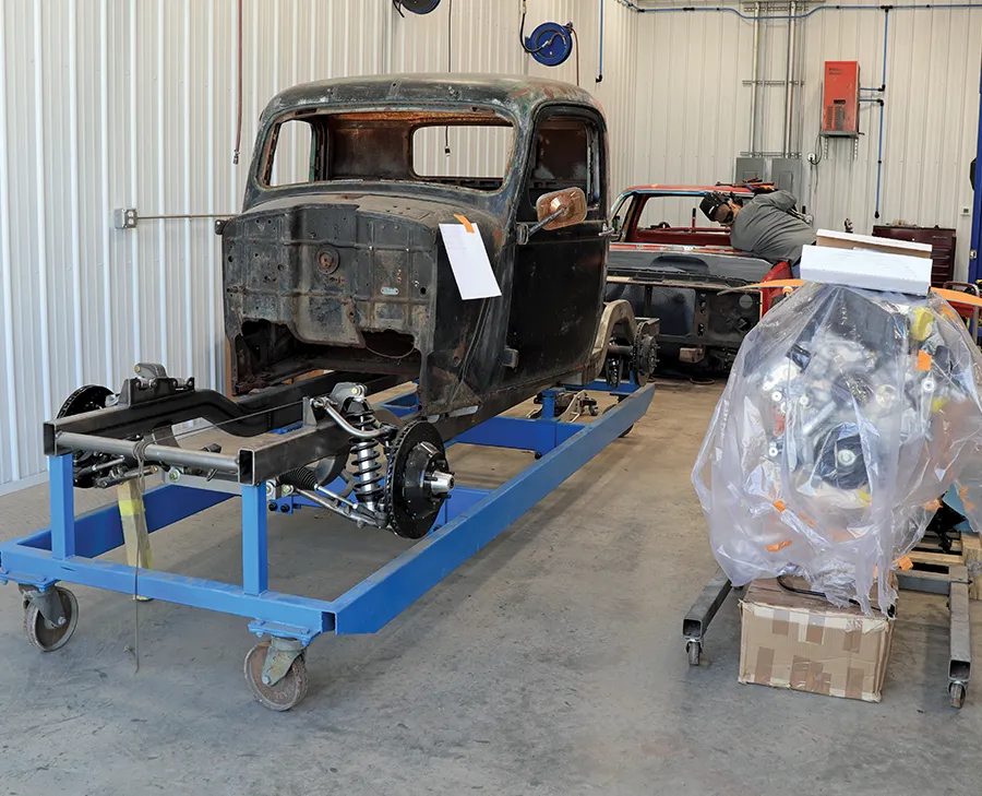 Classic truck cab on custom blue cart with suspension mockup and shop restoration layout
