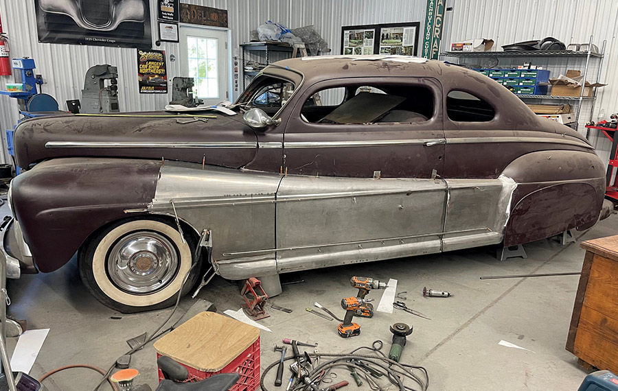 1947 Ford coupe, full side, multiple fadeaway fender panels installed, shop tools scattered