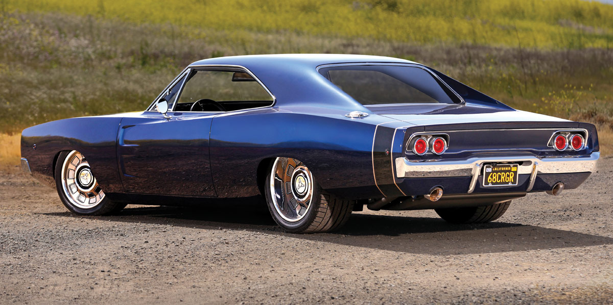 Rear three-quarter view of the customized metallic blue 1968 Dodge Charger showing the custom taillights, chrome bumper, and California license plate "68CRGR".