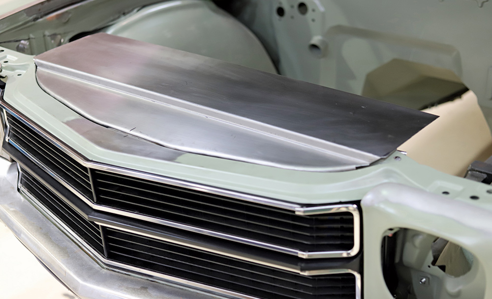 custom-fabricated metal panel installed above the grille