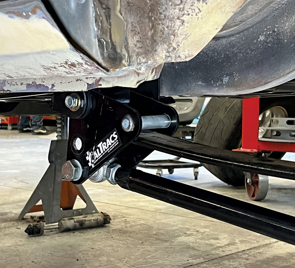 Side view of a car body lifted on a jack stand.