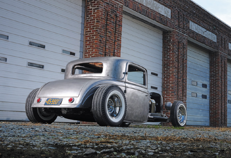 1932 Ford five-window bare-metal rear view showing chopped roof and wide whitewall stance