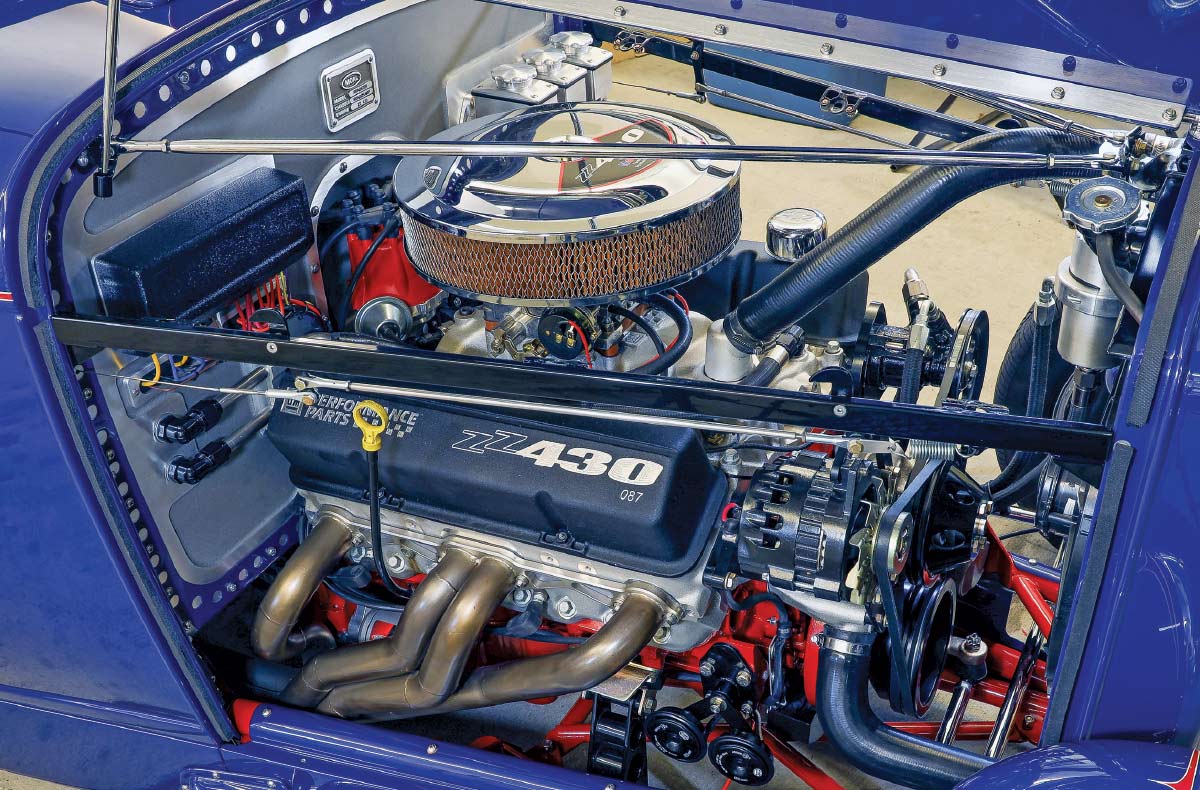 1932 Ford roadster blue side-profile shot highlighting louvers, black top, and wide rear tires