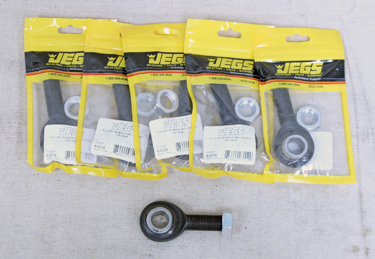 Five JEGS brand three-piece rod ends in yellow packaging with one loose rod end and jam nut in front.