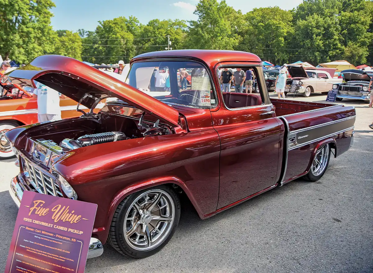 Red 1955 Chevrolet Cameo pickup, hood open, chrome wheels, purple award sign Fire White