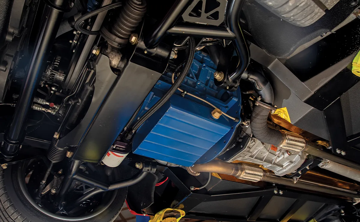 Underside view of a performance vehicle's chassis featuring a blue oil pan, MMR oil filter, and custom suspension components.