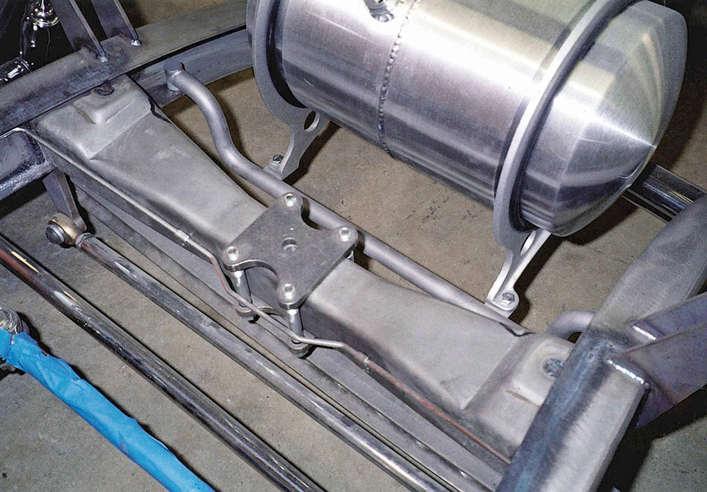 Close-up view of the bare metal prototype SO-CAL Speed Shop Step Boxed frame. A cylindrical Moon tank is mounted to a custom tubular bracket located forward of the front crossmember.