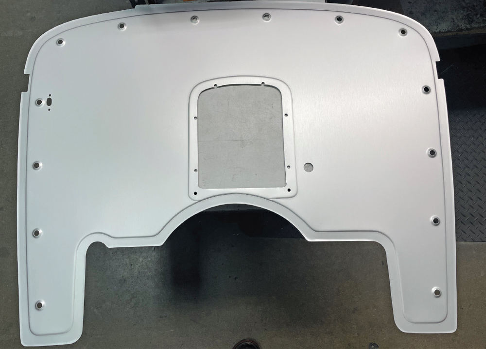 Rear view of a flat, silver aluminum outer firewall panel with a large semi-circular bottom arch and rectangular center opening. Small mounting holes for Dzus fasteners are evenly spaced along the outer perimeter.