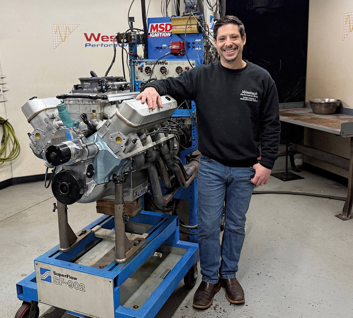 Evan Perkins smiling while leaning on engine