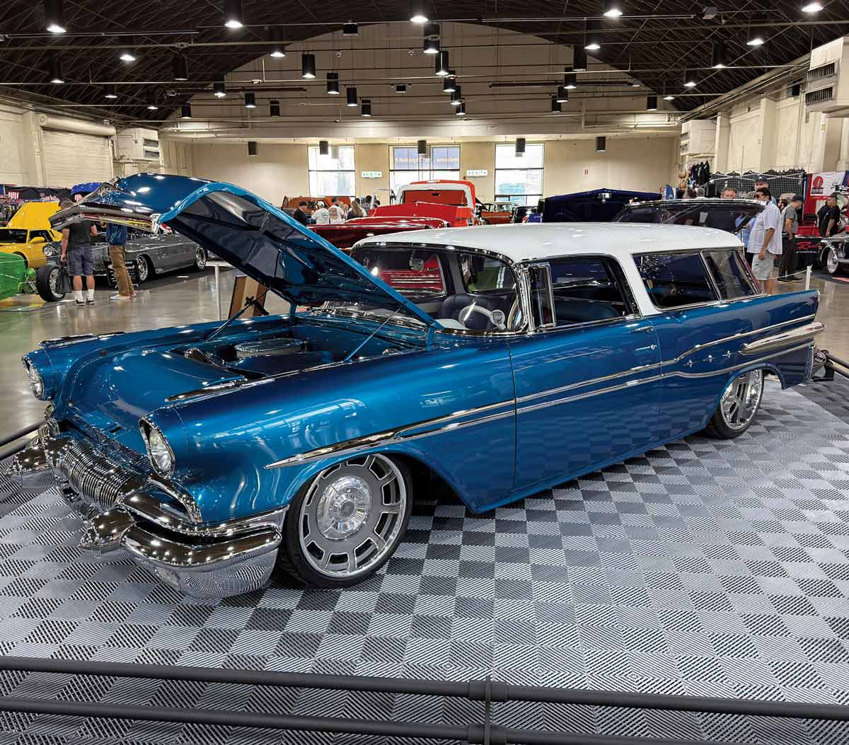 1957 Chevrolet Bel Air dark blue custom lowrider two-door chrome wheels open hood indoor