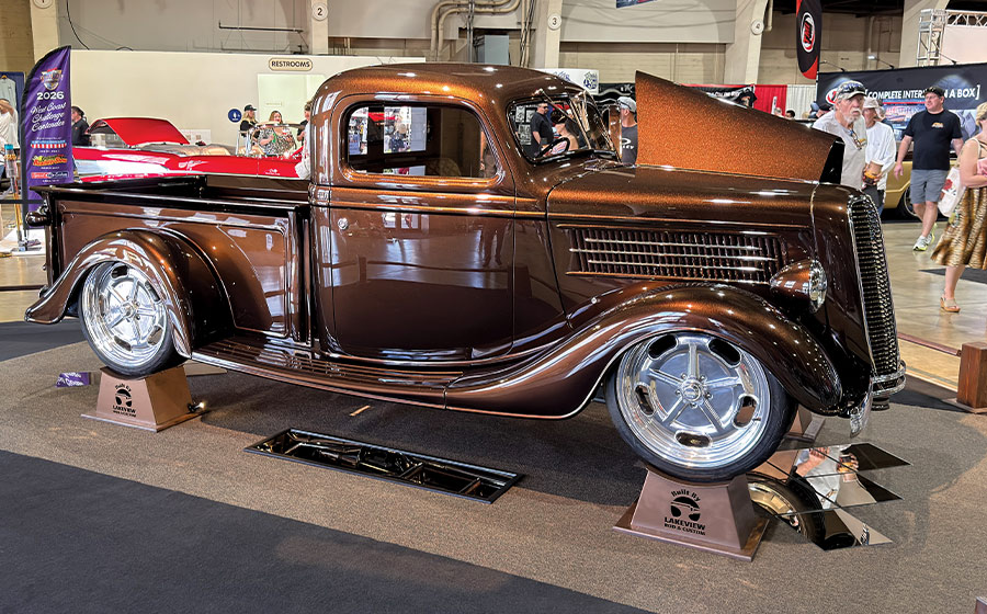 1936 Ford custom pickup truck metallic brown paint displayed at indoor hot rod and custom car show
