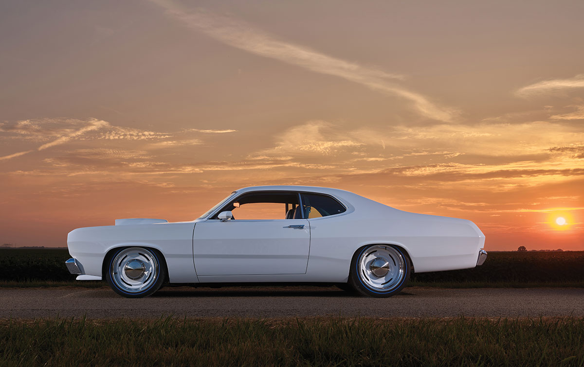 Driver side profile of the white Duster at sunset.
