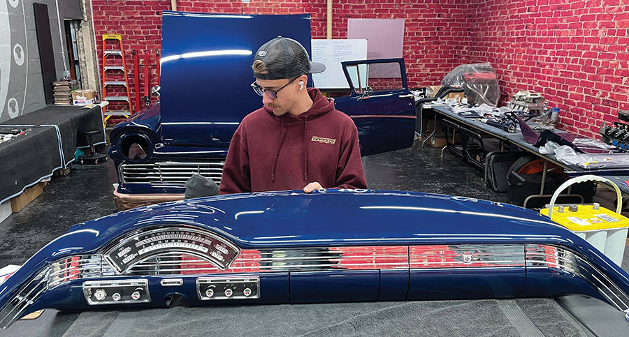 Elijah Schroeder inspecting a blue dashboard.