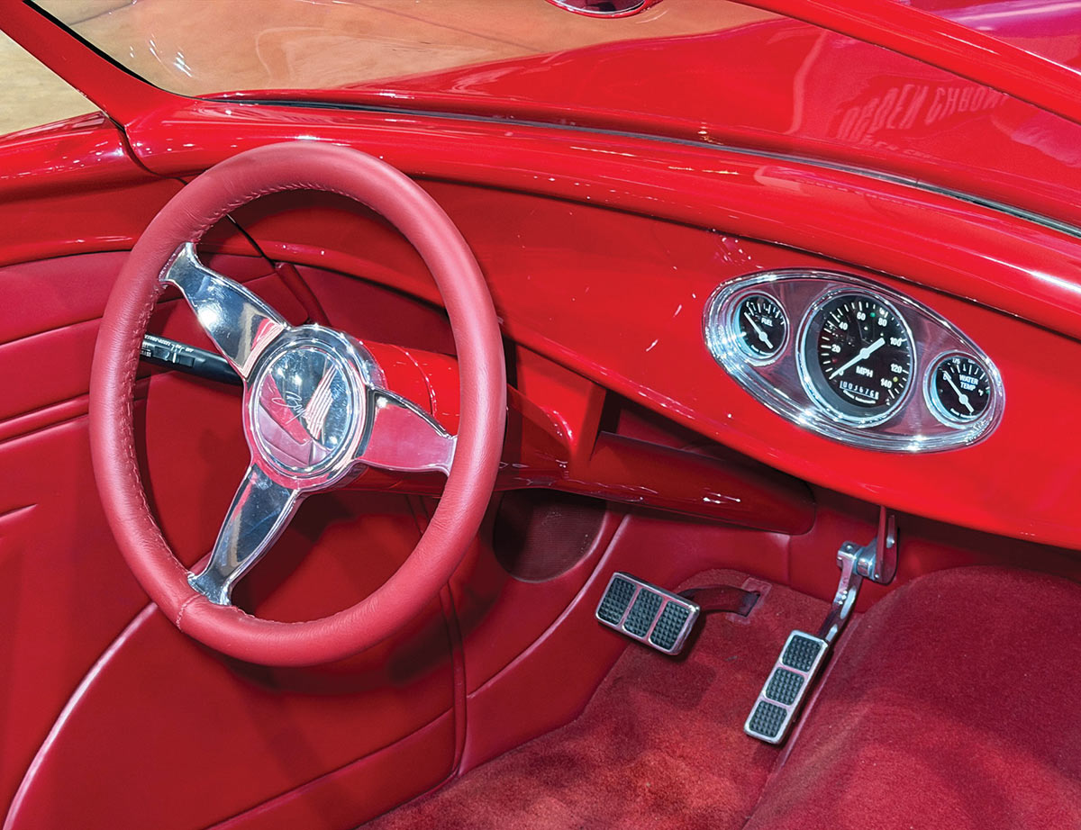 Detailed view of the red leather-wrapped steering wheel and custom gauges.
