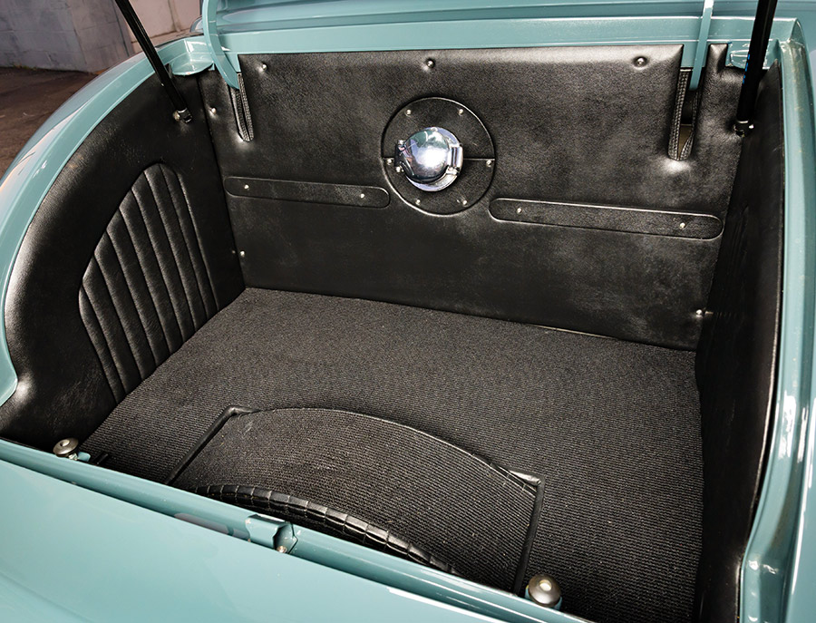 Upholstered trunk compartment with custom battery cover.