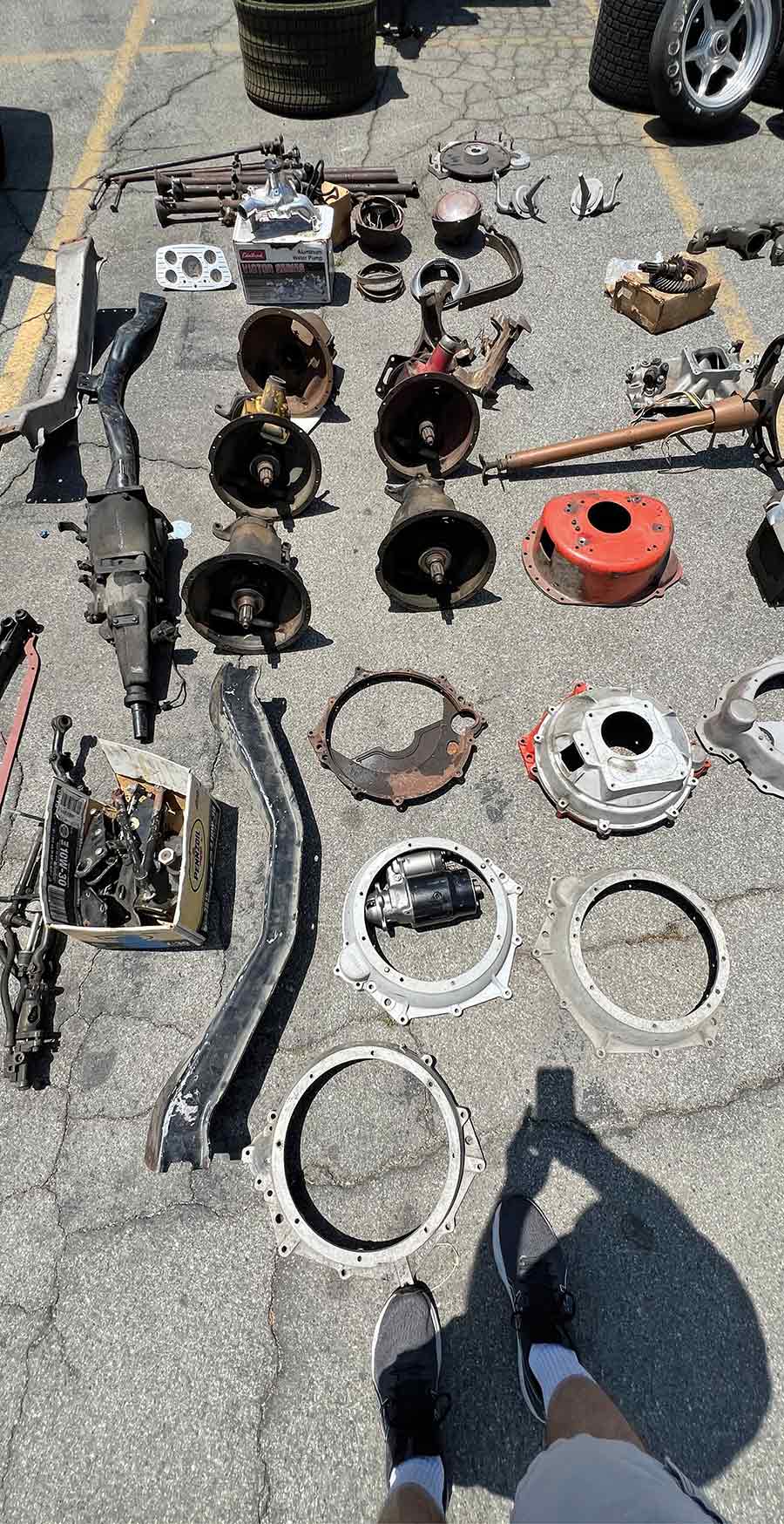 Car components and gearboxes for sale at swap meet.