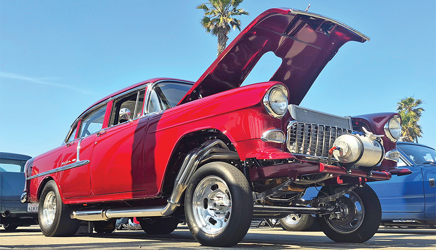 Red four-door 1955 Chevrolet gasser with front-mounted tank