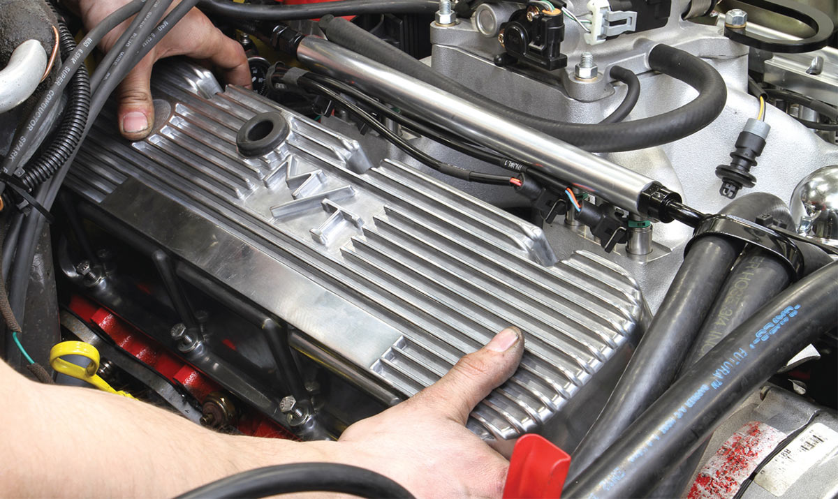 Installing the valve cover onto the completed engine.