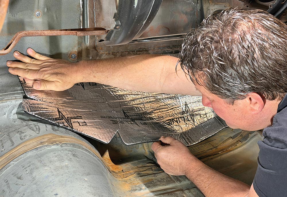 Pressing insulation into the corner of the interior footwell.