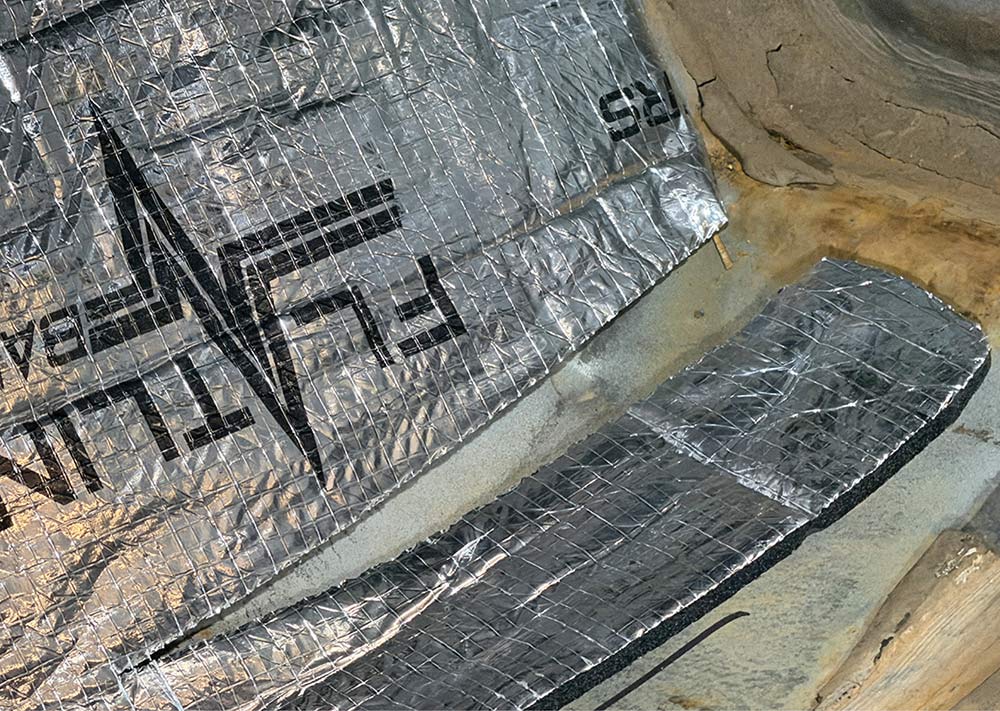 Close-up of insulation molded over floor pan hills and valleys.