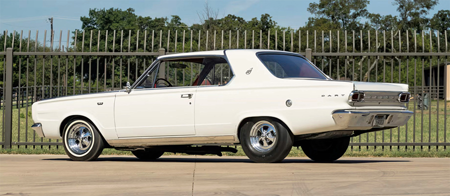 Rear three-quarter view of a vintage white Dodge Dart parked on a concrete surface.
