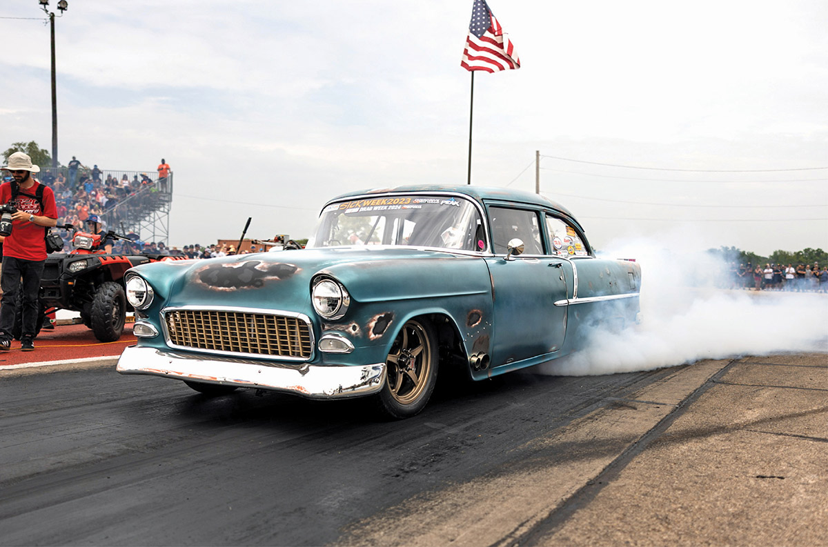 1955 Chevy gasser performing a smoky burnout at the dragstrip.