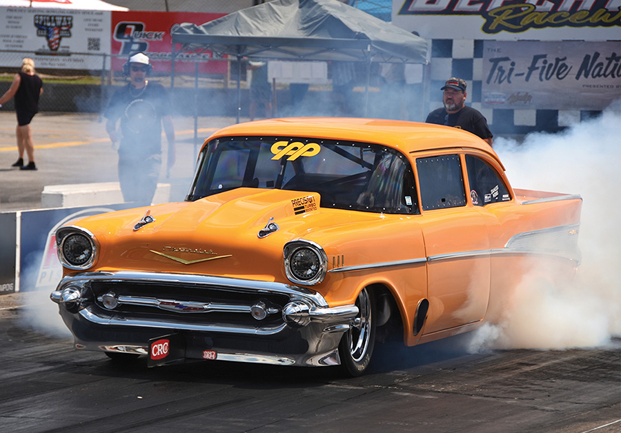 Jeff Lutz performing a burnout in his orange 1957 Chevy.