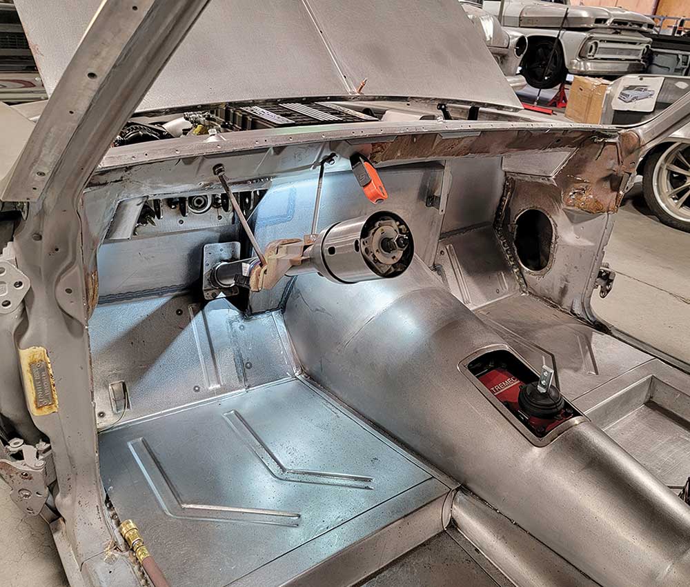 Interior view showing bare metal floor and Ididit steering column.