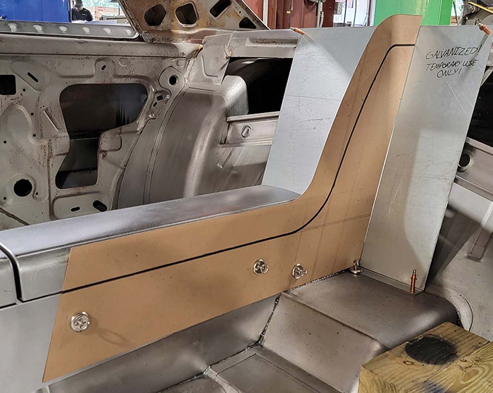 Magnets holding chipboard while shaping lower rear console section.