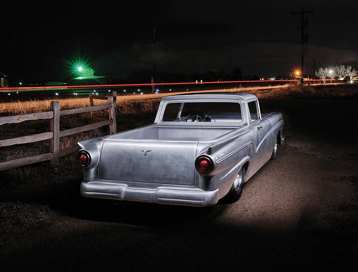 Rear quarter view of the unpainted 1957 Ford Ranchero at night.