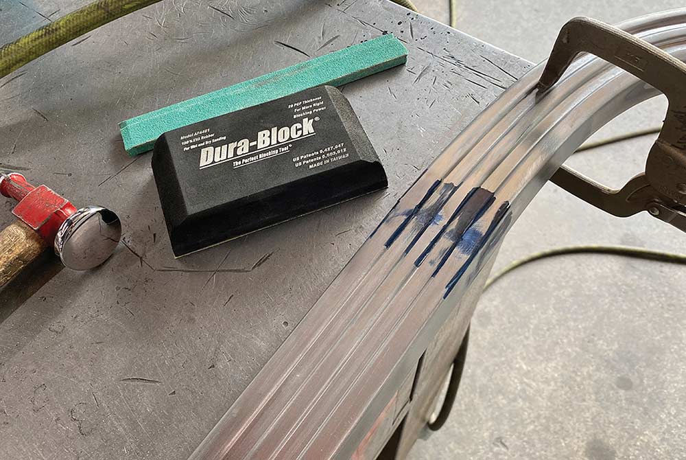 Hand-sanding the weld seams on the stainless trim with a Dura-Block.