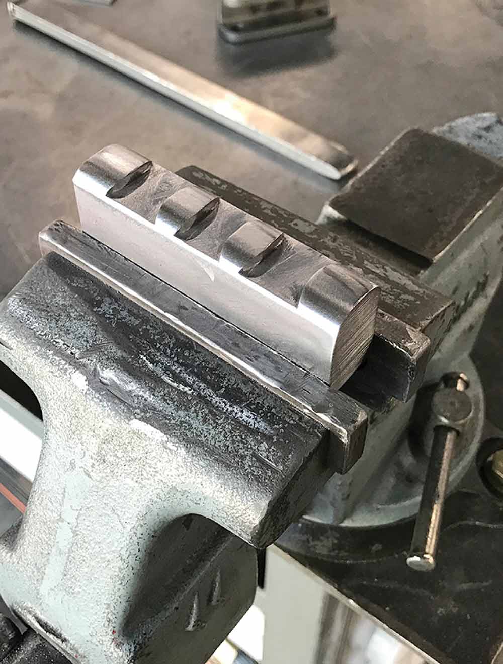 Machined steel die with clearance radii for turning corners.