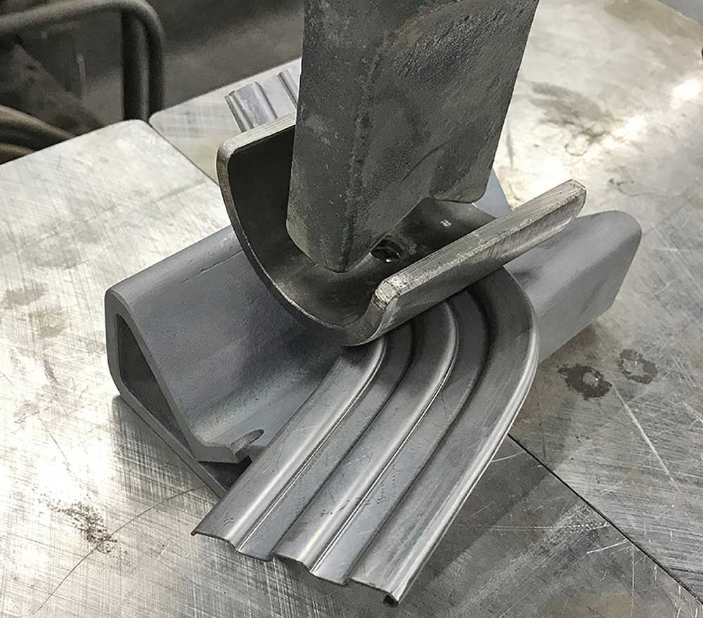 Creating the corner radius using a hydraulic shop press and forming tool.