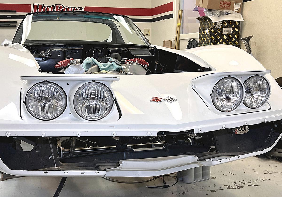 Completed white C3 Corvette with modern lighting and electric doors.