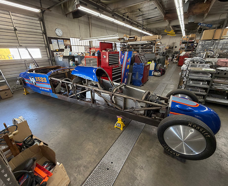 The Mooneyes world land speed record streamliner resting on shop stands.